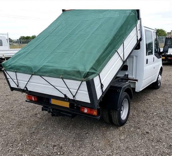 Green mesh cover sheet fitted over a tipper truck flatbed