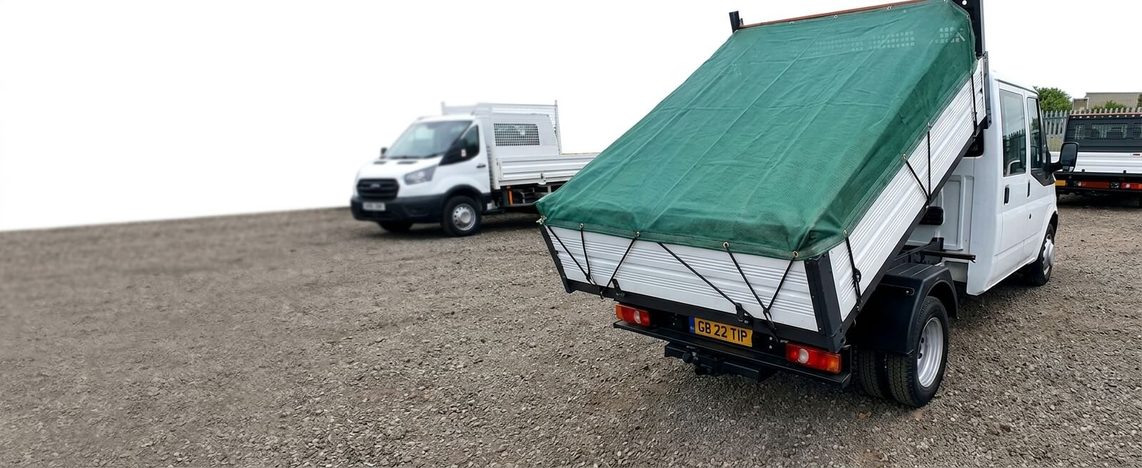 Green mesh cover sheet fitted over a tipper truck bed